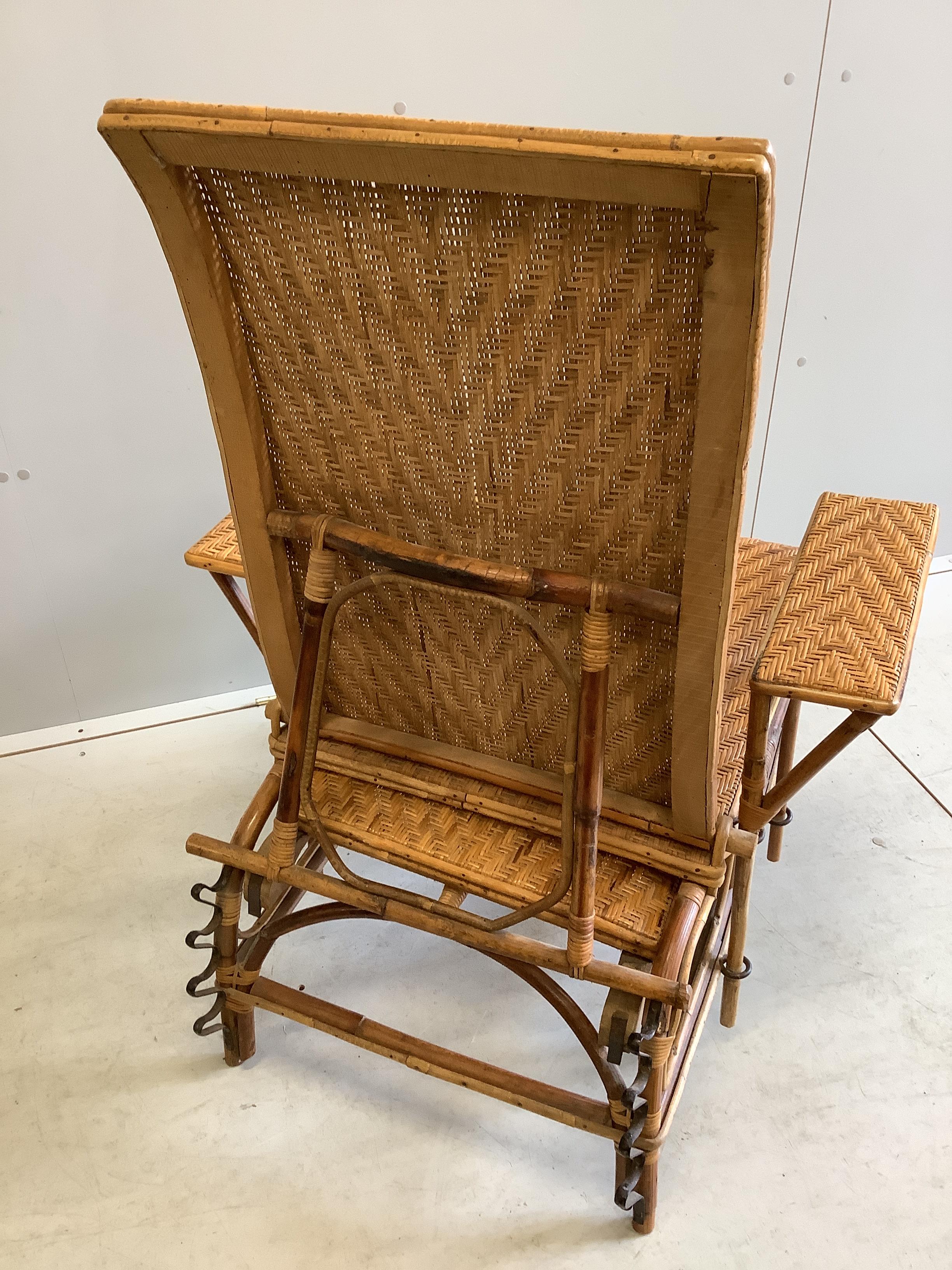 An early 20th century French caned bamboo reclining garden chair, with integral footrest, width 75cm, height 92cm